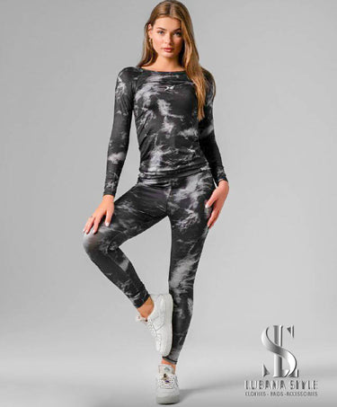 a woman is wearing a black& white sportswear for gym 